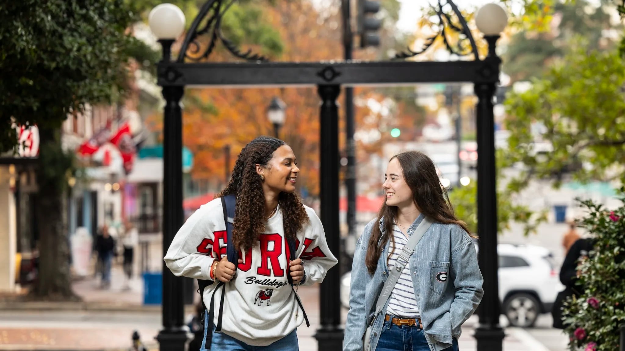 Two young women are pictured near the UGA arch.
