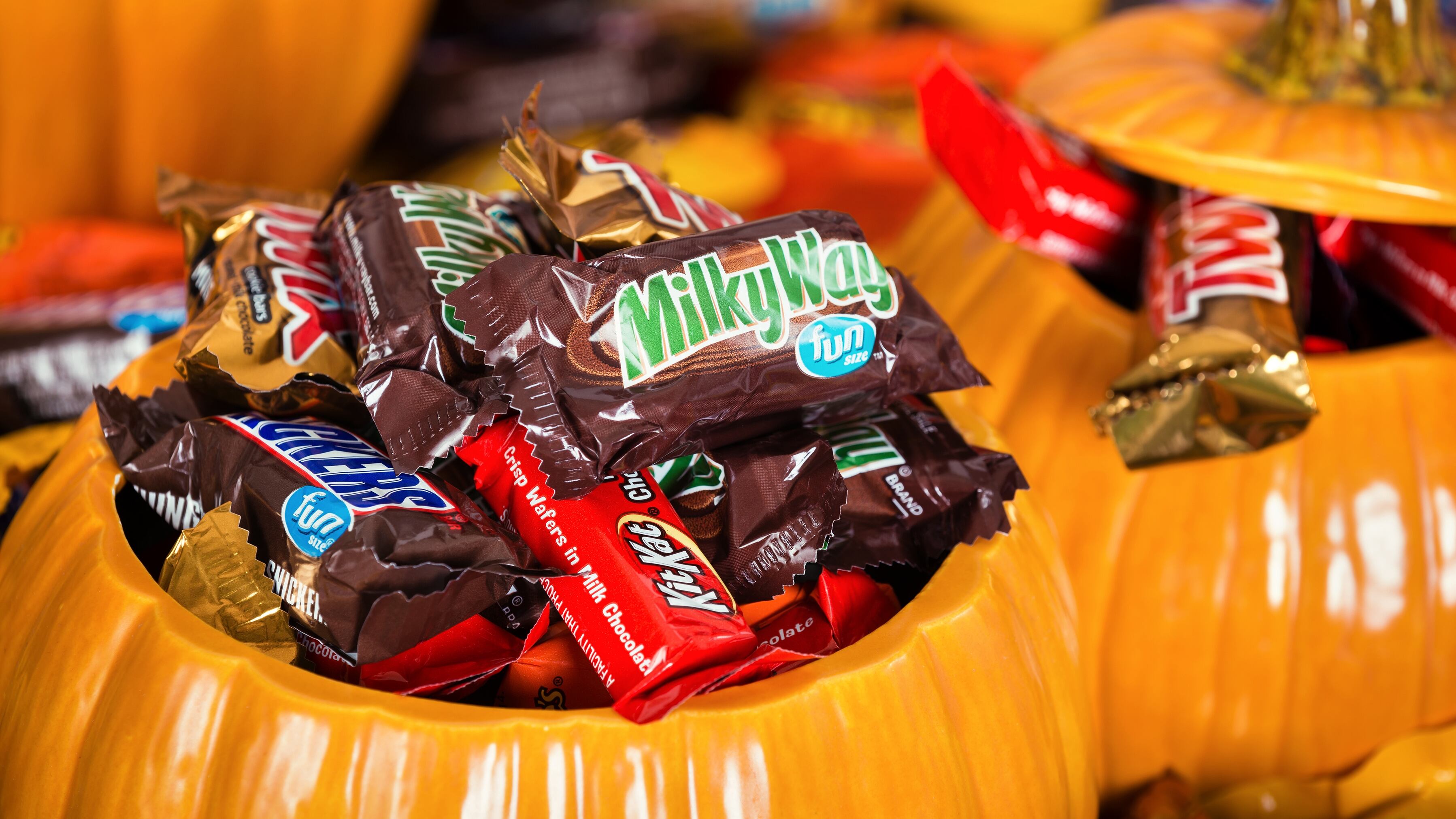 Decorative pumpkins filled with assorted Halloween chocolate candy made by Mars, Incorporated and the Hershey Company.